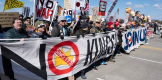 Las personas sostienen carteles y pancartas mientras participan en la marcha 'No Kings' (No reyes) en Washington.