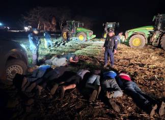 Agente de PNC revisa los recipientes que contienen diésel robado.