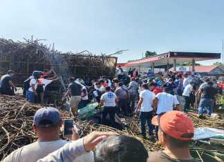 Personas ayudan a bomberos para rescartar a heridos por el camión que volcó en Tiquisate. Foto: Bomberos Voluntarios