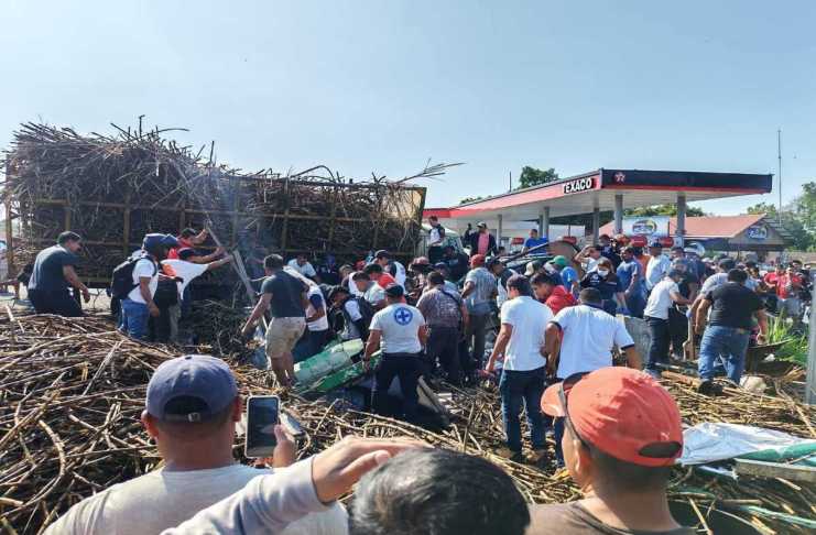 Personas ayudan a bomberos para rescartar a heridos por el camión que volcó en Tiquisate. Foto: Bomberos Voluntarios