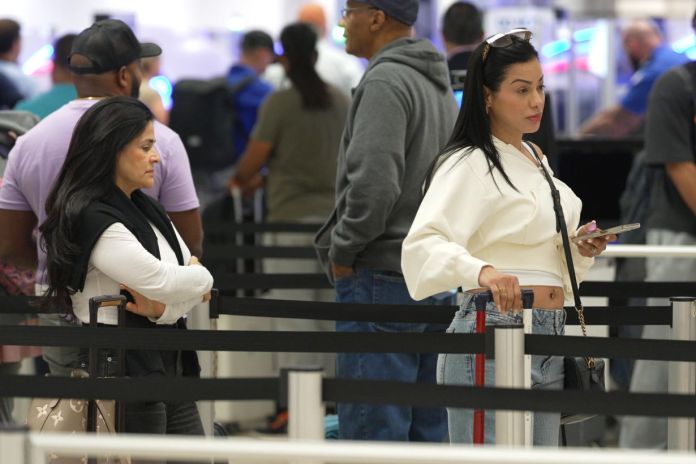Personas esperan en la fila para abordar un avión este jueves, en el aeropuerto Internacional de Miami en Florida, Estados Unidos. Foto La Hora: EFE