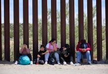 Una familia migrante espera en la frontera de Estados Unidos. Foto: EFE/EPA/Allison Dinner