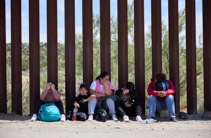 Una familia migrante espera en la frontera de Estados Unidos. Foto: EFE/EPA/Allison Dinner