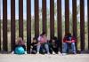 Una familia migrante espera en la frontera de Estados Unidos. Foto: EFE/EPA/Allison Dinner