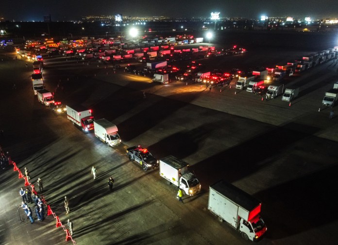 Fotografía aérea que muestra camiones que transportan material electoral hacia los locales de votación en Lima Metropolitana y el Callao en el marco de las elecciones generales de este domingo.