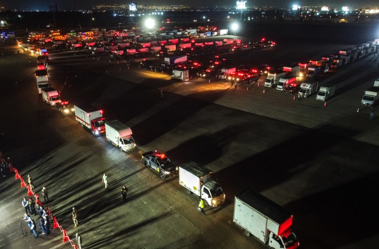 Fotografía aérea que muestra camiones que transportan material electoral hacia los locales de votación en Lima Metropolitana y el Callao en el marco de las elecciones generales de este domingo.