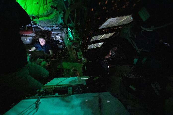 La astronauta de la NASA Christina Koch es iluminada por una pantalla dentro de la nave espacial Orión oscurecida. Foto La Hora: NASA
