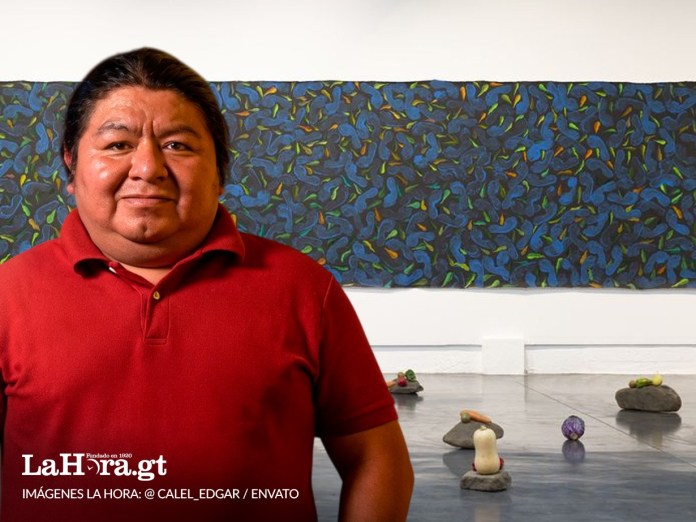 Edgar Calel. Artista y poeta comalapense junto con una obra en su exposición en La Nueva Fábrica. Foto La Hora