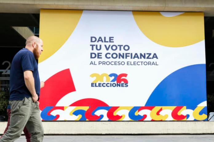AME6869. BOGOTÁ (COLOMBIA), 30/05/2026.- Una persona camina frente a un cartel alusivo a las elecciones presidenciales de 2026 en el recinto ferial de Corferias este sábado, en Bogotá (Colombia). Las autoridades colombianas ultiman los preparativos para la primera vuelta de las elecciones presidenciales de este domingo para las que están habilitados 41.421.973 ciudadanos que podrán votar para elegir al sucesor de Gustavo Petro, el actual mandatario, quien no puede presentarse a la reelección porque no lo permite la Constitución. Foto: La Hora/ EFE/ Carlos Ortega