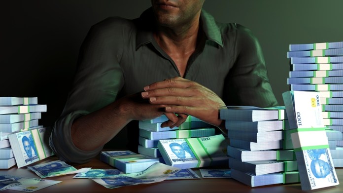 Man,Sitting,In,Front,Of,Table,Full,Of,Stacks,Of La Superintendencia de Bancos advierte importancia de aprobar la Ley Antilavado para cumplir con estándares internacionales. Foto La Hora: RODWORKS/Shutterstock