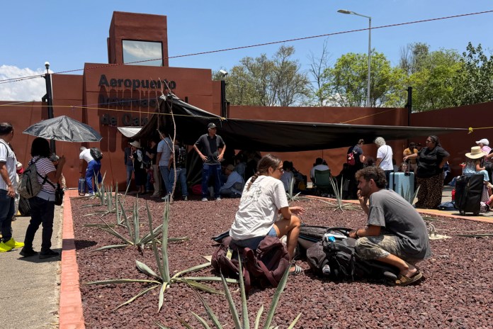 Personas esperan afuera del Aeropuerto Internacional de Oaxaca este viernes, en Oaxaca (México). Foto La Hora: EFE