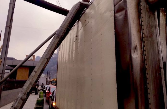 Uno de los dos postes derribados por un camión en la Calzada La Paz cayó sobre un vehículo. Foto La Hora: A. Montejo
