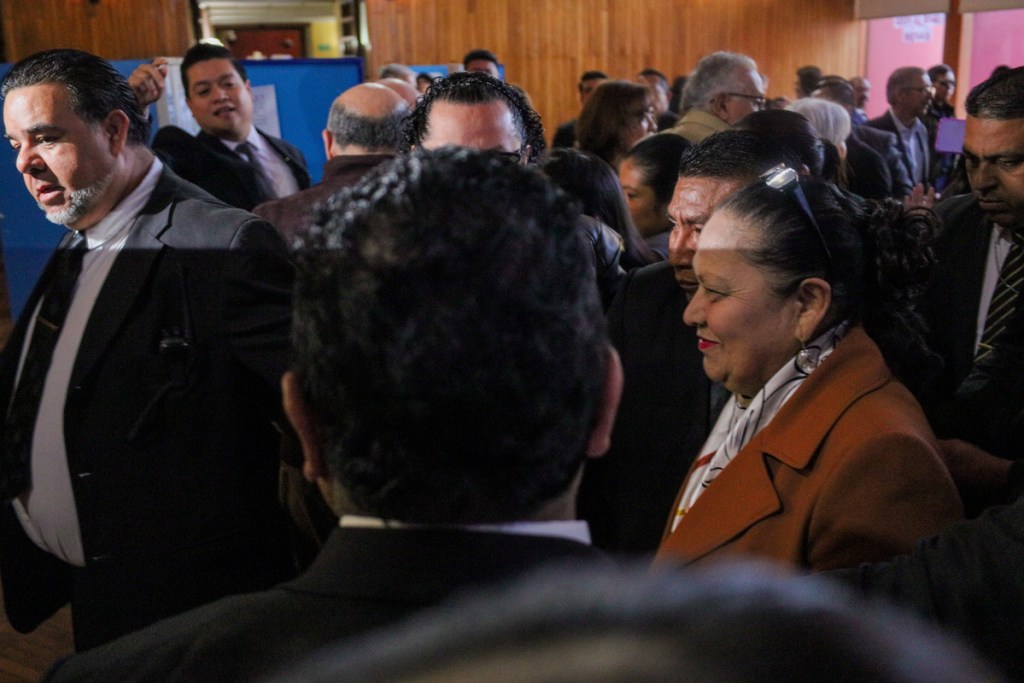 La ex fiscal general Consuelo Porras se abre paso entre un cordón de seguridad humano por parte de sus guardaespaldas. Foto La Hora: Daniel Ramírez.
