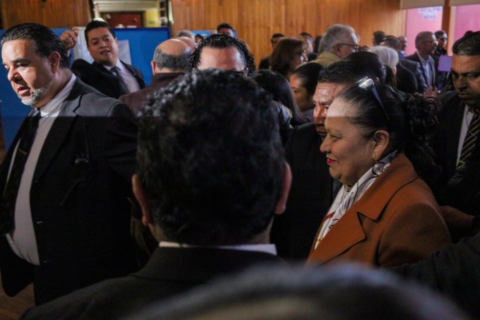 La ex fiscal general Consuelo Porras se abre paso entre un cordón de seguridad humano por parte de sus guardaespaldas. Foto La Hora: Daniel Ramírez.