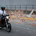 Un motociclista transita cerca de escombros este miércoles, en Caracas (Venezuela). Un terremoto de magnitud 7.1. Foto La Hora: EFE