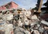 Un brigadista y un perro rescatistas inspeccionan en los escombros de un edificio que colapsó por los terremotos, en La Guaira, Venezuela. Foto: EFE.