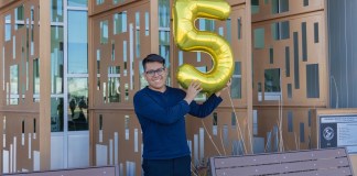Fotografía divulgada por el Distrito de Escuelas Secundarias Phoenix Union donde aparece Joseph Parra Miguel, de 18 años e hijo de inmigrantes mexicanos, sosteniendo un globo en forma del número cinco en alusión a su logro de 5 millones de dólares en becas.