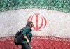 El mundo reacciona con optimismo cauteloso ante el anuncio de un acuerdo entre Irán y EE. UU. Mujer frente a bandera de Irán