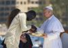 El papa León XIV recibe flores de dos voluntarios para protagonizar una ofrenda floral en el mar en recuerdo de los migrantes muertos. Foto La Hora: EFE