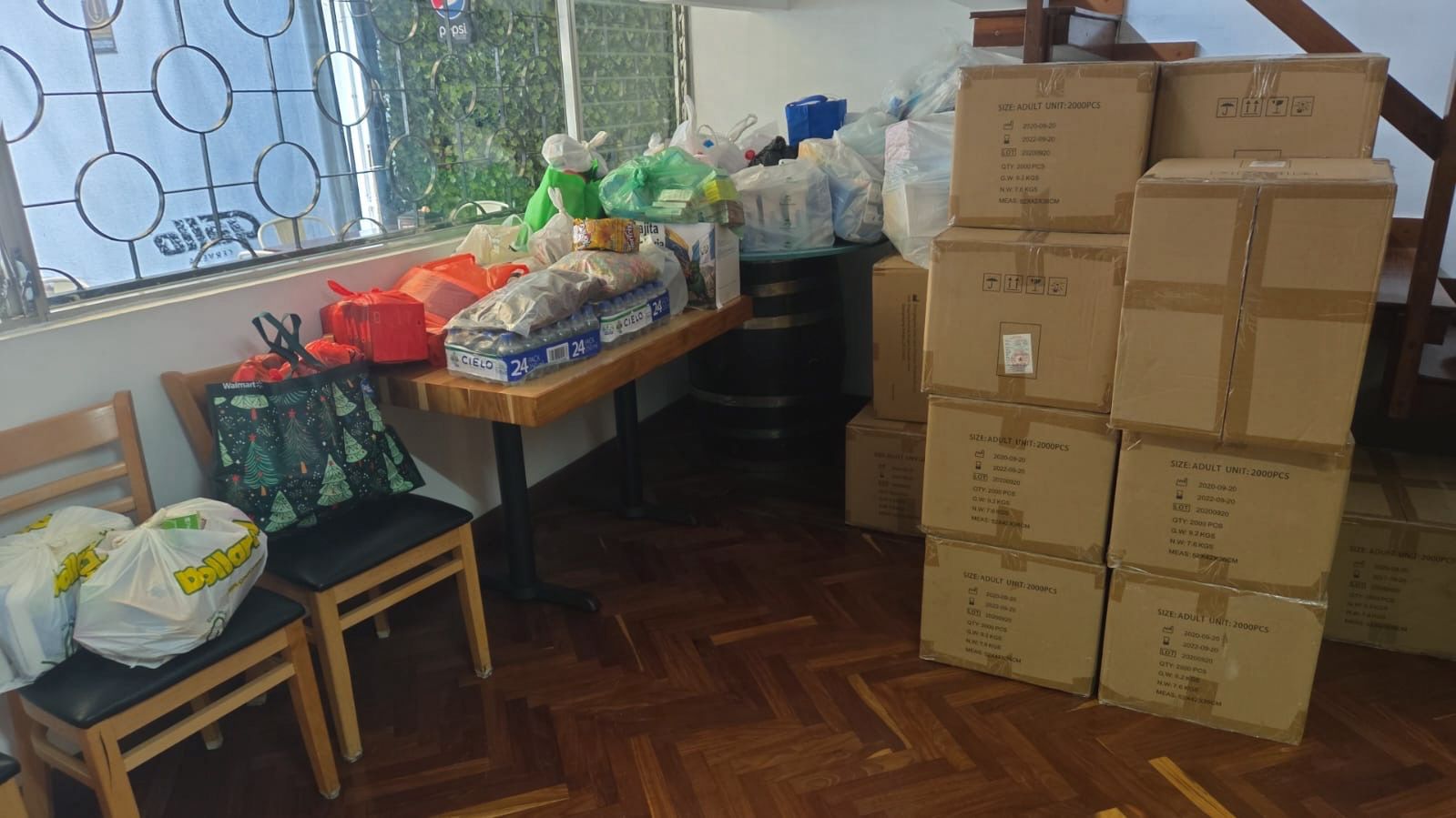 Tras recibir las donaciones, voluntarios de la comunidad venezolana proceden a su embalaje.