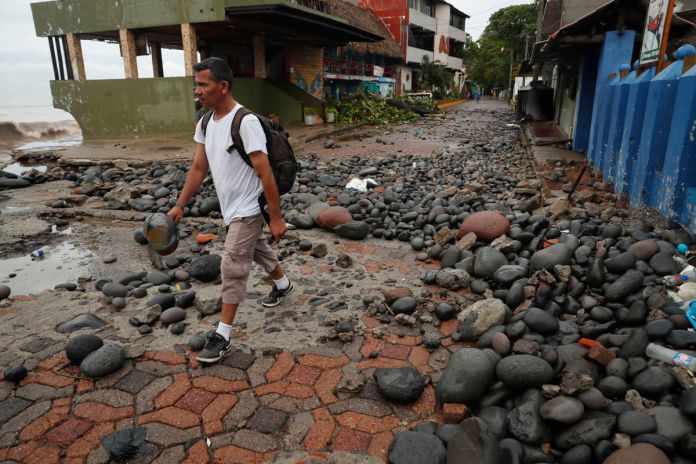 Una persona camina entre piedras desbordadas por el oleaje en el Puerto de La Libertad, El Salvador, tras la tormenta tropical Cristina. Una persona camina entre piedras desbordadas por el oleaje en el Puerto de La Libertad, El Salvador, tras la tormenta tropical Cristina. Foto La Hora: EFE