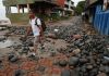 Una persona camina entre piedras desbordadas por el oleaje en el Puerto de La Libertad, El Salvador, tras la tormenta tropical Cristina. Foto La Hora: EFE