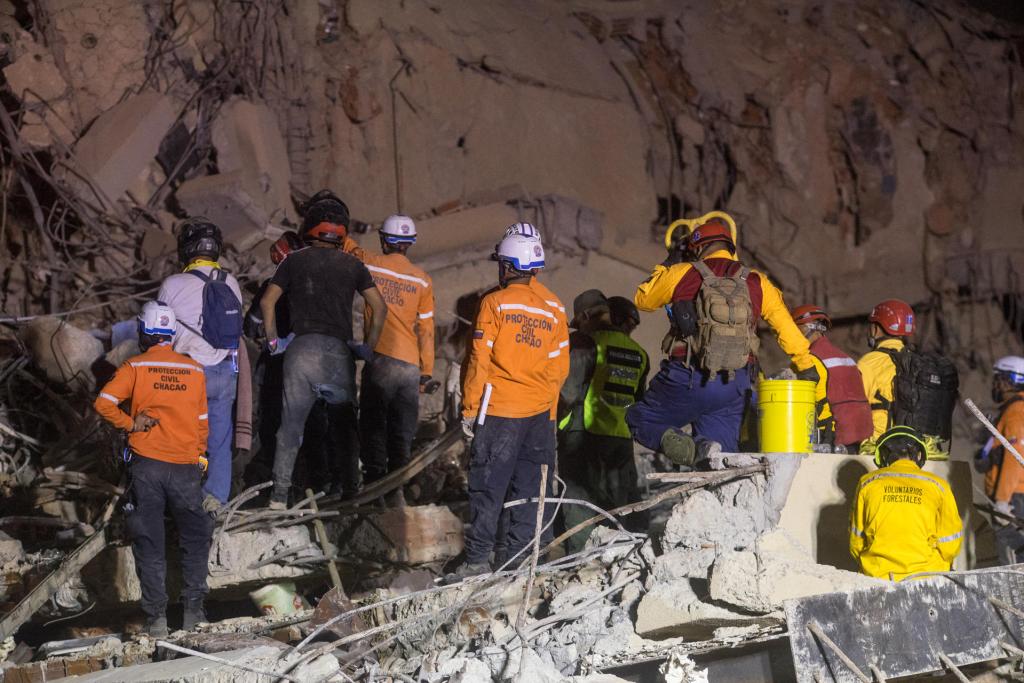 Integrantes de equipos de rescate trabajan en un edifico afectado por el terremoto en Venezuela