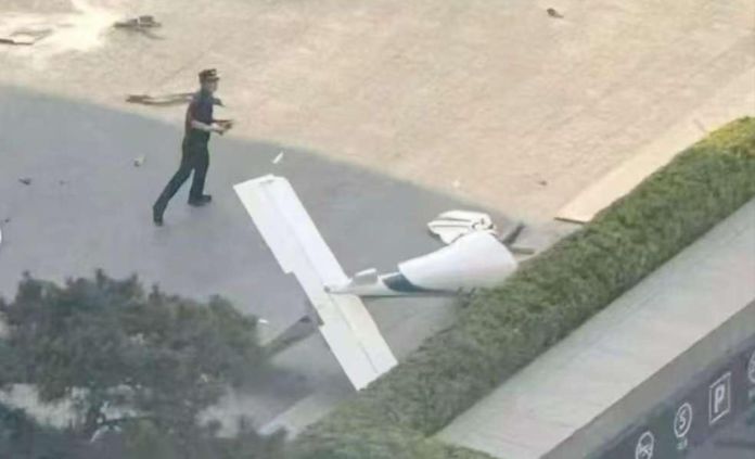 Fotografía cedida que muestra un integrante de la Policía de China frente a un fragmento de una aeronave en una vía próxima al edificio China Zun. Foto La Hora: EFE-cortesía