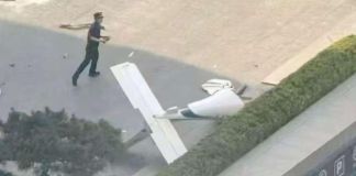 Fotografía cedida que muestra un integrante de la Policía de China frente a un fragmento de una aeronave en una vía próxima al edificio China Zun. Foto La Hora: EFE-cortesía