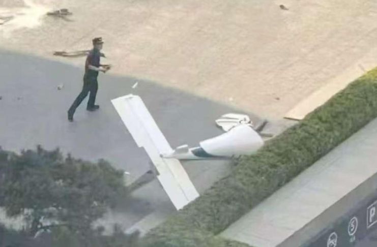 Fotografía cedida que muestra un integrante de la Policía de China frente a un fragmento de una aeronave en una vía próxima al edificio China Zun. Foto La Hora: EFE-cortesía