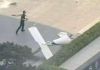 Fotografía cedida que muestra un integrante de la Policía de China frente a un fragmento de una aeronave en una vía próxima al edificio China Zun. Foto La Hora: EFE-cortesía