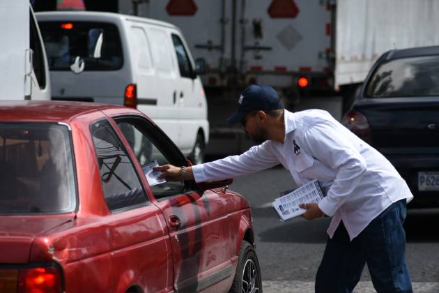 Un participante en el plant&oacute;n entrega volantes a un automovilista.