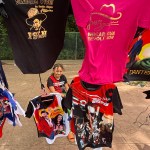 Una niña ayuda a vender a sus padres camisetas con imágenes estampadas del presidente de Nicaragua, Daniel Ortega, durante la celebración del 47 aniversario de la revolución que derrocó por la vía armada a la dictadura de Anastasio Somoza Debayle. Foto La Hora: EFE