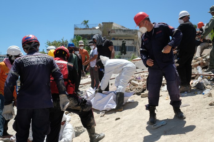 Venezuela suma 3.685 muertes por sismos mientras economistas piden el fin de las sanciones Bomberos y voluntarios rescatan un cuerpo sin vida durante los trabajos de remoción de escombros de los edificios Misión Vivienda OPPE por los terremotos en Venezuela. Foto La Hora: EFE