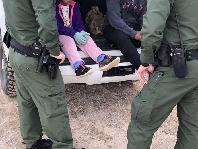 Fotografía de archivo donde aparecen dos agentes de la Patrulla Fronteriza mientras atienden a unos niños en un punto del área conocido como Quitobaquito, en la frontera de Arizona con México. Foto La Hora: EFE