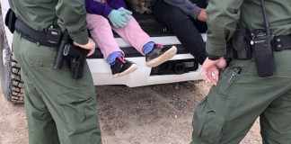 Arizona frena centro de detención de migrantes de Surprise por falta de estudio ambiental Fotografía de archivo donde aparecen dos agentes de la Patrulla Fronteriza mientras atienden a unos niños en un punto del área conocido como Quitobaquito, en la frontera de Arizona con México. Foto La Hora: EFE