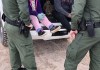 Fotografía de archivo donde aparecen dos agentes de la Patrulla Fronteriza mientras atienden a unos niños en un punto del área conocido como Quitobaquito, en la frontera de Arizona con México. Foto La Hora: EFE