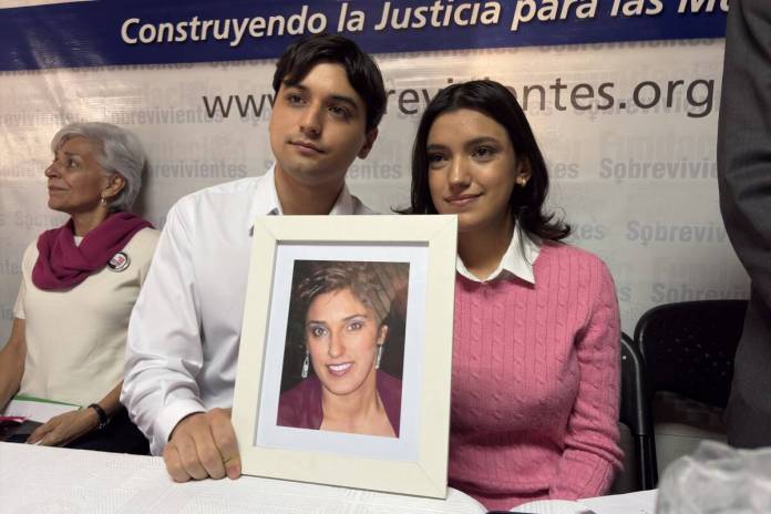 Roberto José y María Mercedes Barreda Siekavizza, hijos de Cristina, junto a un retrato de su madre durante la conferencia de prensa con la que la familia conmemoró los 15 años de su desaparición. Foto La Hora: José Orozco.