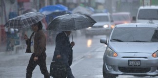Dos personas caminan bajo la lluvia en la zona 1 de la ciudad de Guatemala, donde este domingo se prevén precipitaciones dispersas acompañadas de actividad eléctrica, según el Insivumeh