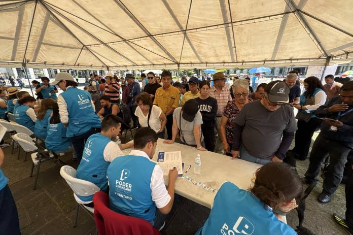 Un ciudadano firma la petición de Poder Ciudadano en la Plaza de la Constitución, durante la primera jornada de recolección de apoyos para impulsar una reforma al sistema de justicia.