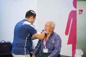Un adulto mayor recibiendo un chequeo médico.