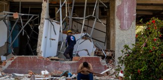 Una persona se lamenta frente a un edificio destruido por los terremotos del 24 de junio en Caraballeda, Venezuela. Foto La Hora: EFE