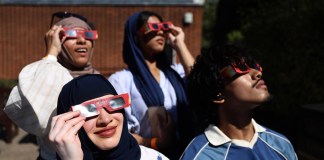 LONDON (United Kingdom), 12/08/2026.- People shield their eyes with protective glasses during an eclipse event at Greenwich Observatory in London, Britain, 12 August 2026. A solar eclipse is when the Moon passes in front of the Sun and blocks its light. In London, more than 90 percent of the Sun was obscured at the peak of the eclipse. The eclipse occurred in the UK from 18:17 to 20:06, reaching its peak at 19:12. (Reino Unido, Londres) EFE/EPA/NEIL HALL