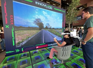 Una chica sentada y con gafas de realidad virtual frente a una pantalla que muestra su visión en un proyecto captado por los estudiantes.