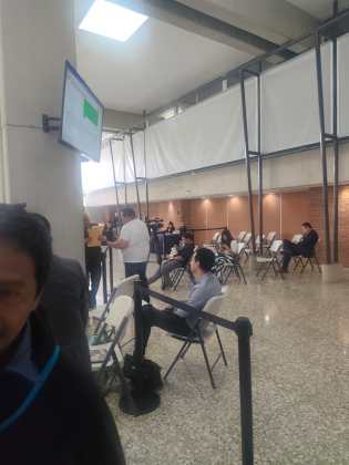 Byron Mej&iacute;a, decano de la Usac, recibiendo un paquete en medio de la sesi&oacute;n de la Postuladora. Foto la Hora: