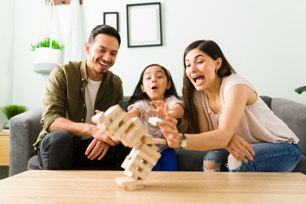 Una niña jugando jenga con su papá y su mamá