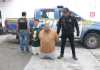 Los dos detenidos permanecen arrodillados junto a agentes de la PNC tras el operativo en Santa Elena Barillas, Villa Canales.