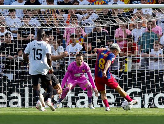 El jugador del Barcelona Pedro González "Pedri", remata para marcar gol contra el Valencia. Foto La Hora: Agencia EFE/ Biel Aliño.
