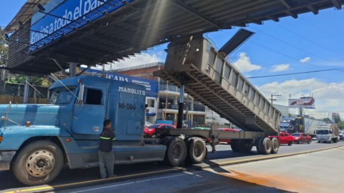Trailer pasarela aguilar batres En la calzada Raúl Aguilar Batres la góndola de un tráiler se levantó e impactó contra la pasarela, mientras que en la Avenida Castellana un cabezal impactó contra un árbol hasta derribarlo. Foto La Hora: captura de video PMT de Villa Nueva y redes sociales