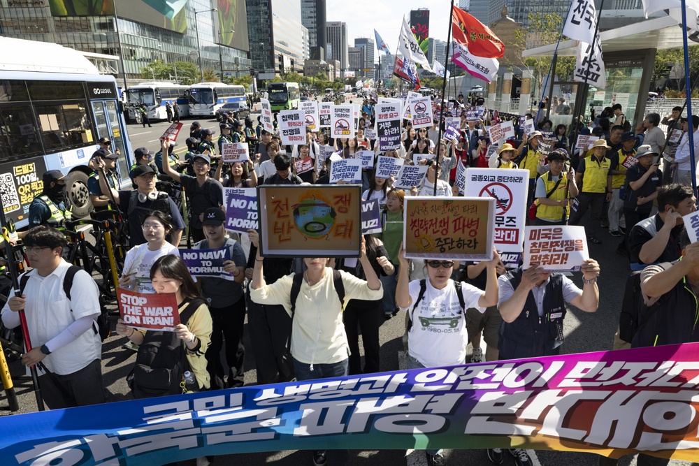 Miembros de grupos cívicos corean consignas mientras marchan hacia la oficina presidencial durante una manifestación contra la presión del presidente Trump para que Corea del Sur envíe tropas al estrecho de Ormuz. Foto La Hora: EFE